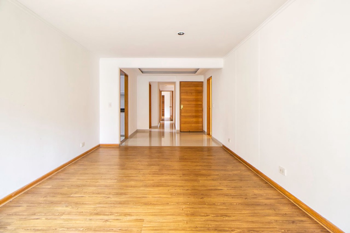 An empty apartment room with wood-look laminate flooring