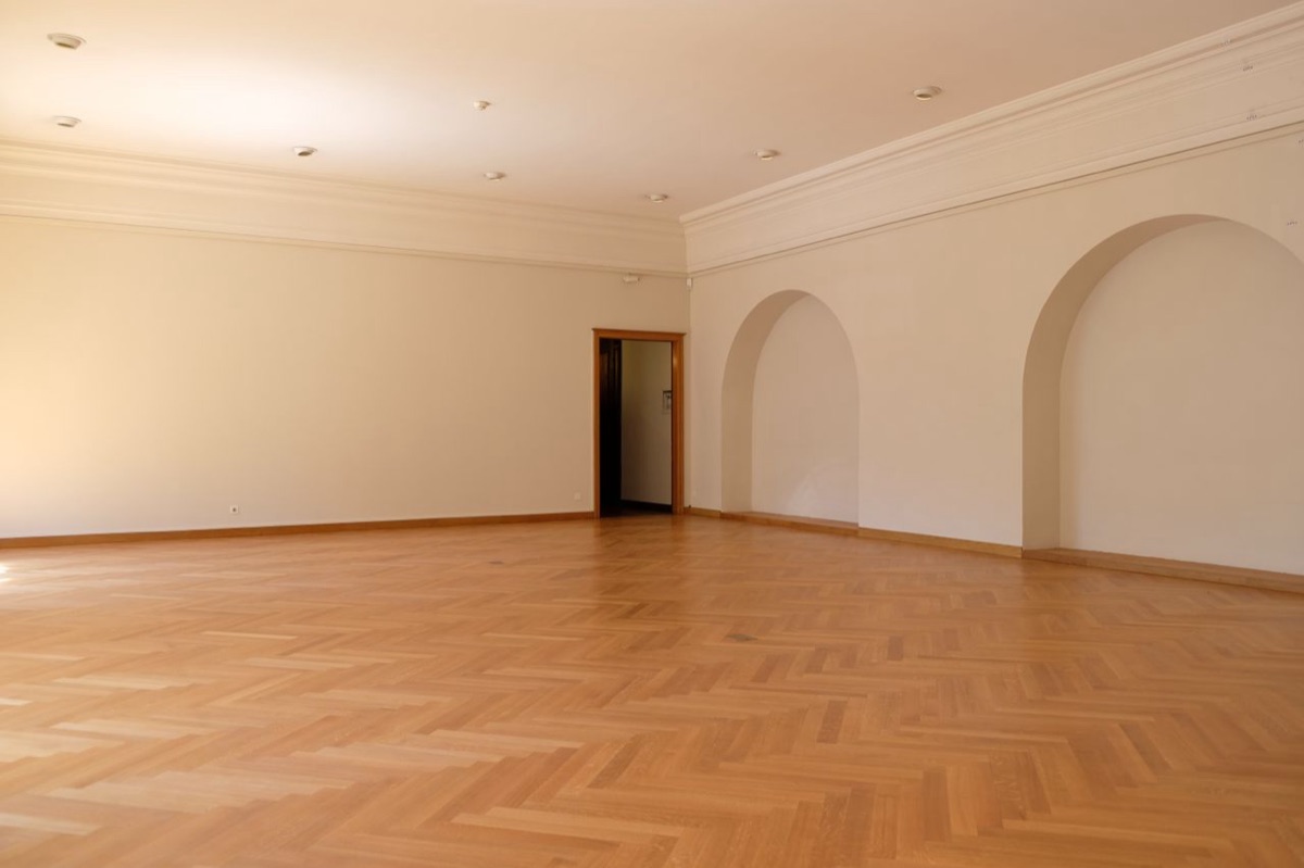 A large empty room with parquet wood flooring