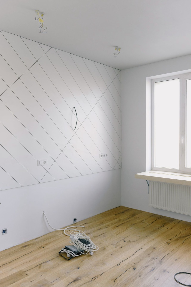 A room mid-renovation with a freshly laid wood floor